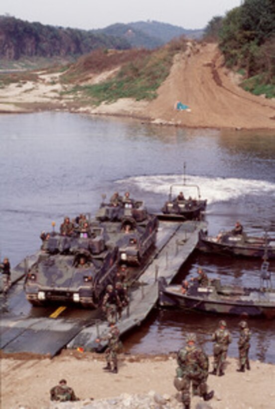 Two M-2 Bradley Fighting Vehicles prepare to drive off a section of floating bridge after crossing the Imjin River in the Republic of Korea, during a bridge building training exercise on Oct. 22, 1998. Soldiers assigned to the 50th Engineer Company, 1st Platoon, and the 2nd Battalion, 9th Infantry, are participating in the exercise as part of the U.S. Army Officer Professional Development Program, which is designed to improve team building and soldiery. The 50th Engineers are from Camp Laguardia and the 9th Infantry are from Camp Casey in the Republic of Korea. 