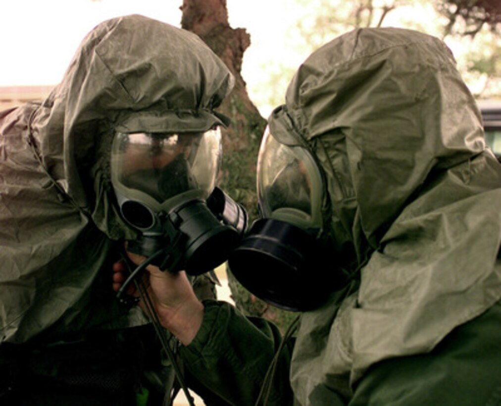 Wyoming Air National Guard Staff Sgt. Mike Abbott (left) has his gas mask adjusted by Senior Airman Scott Humphries (right) during a simulated chemical attack at Kunsan Air Base, Republic of Korea, on Oct. 28, 1998, during Exercise Foal Eagle '98. Foal Eagle '98 is a combined, joint exercise supported by forces from the U.S. and Republic of Korea. In addition to providing hands-on field experience for forces of both nations, Foal Eagle '98 was designed to test rear area protection operations and major command, control and communications systems. Abbott is assigned to the 153rd Security Forces Squadron of the Wyoming Air National Guard. Humphries is assigned to the 137th Security Forces Squadron, Peterson Air Force Base, Colo. 