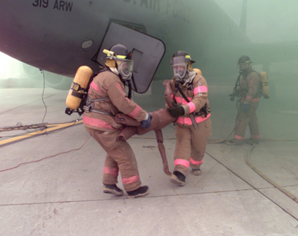 Firefighters from the Grand Forks International Airport fire department remove a life-size dummy from a simulated burning U.S. Air Force KC-135 Stratotanker at Grand Forks, N.D., on Oct. 15, 1998. The rescue was a part of a joint Major Accident Response Exercise conducted at the airport with the firefighters and military personnel from Grand Forks Air Force Base, N.D. 