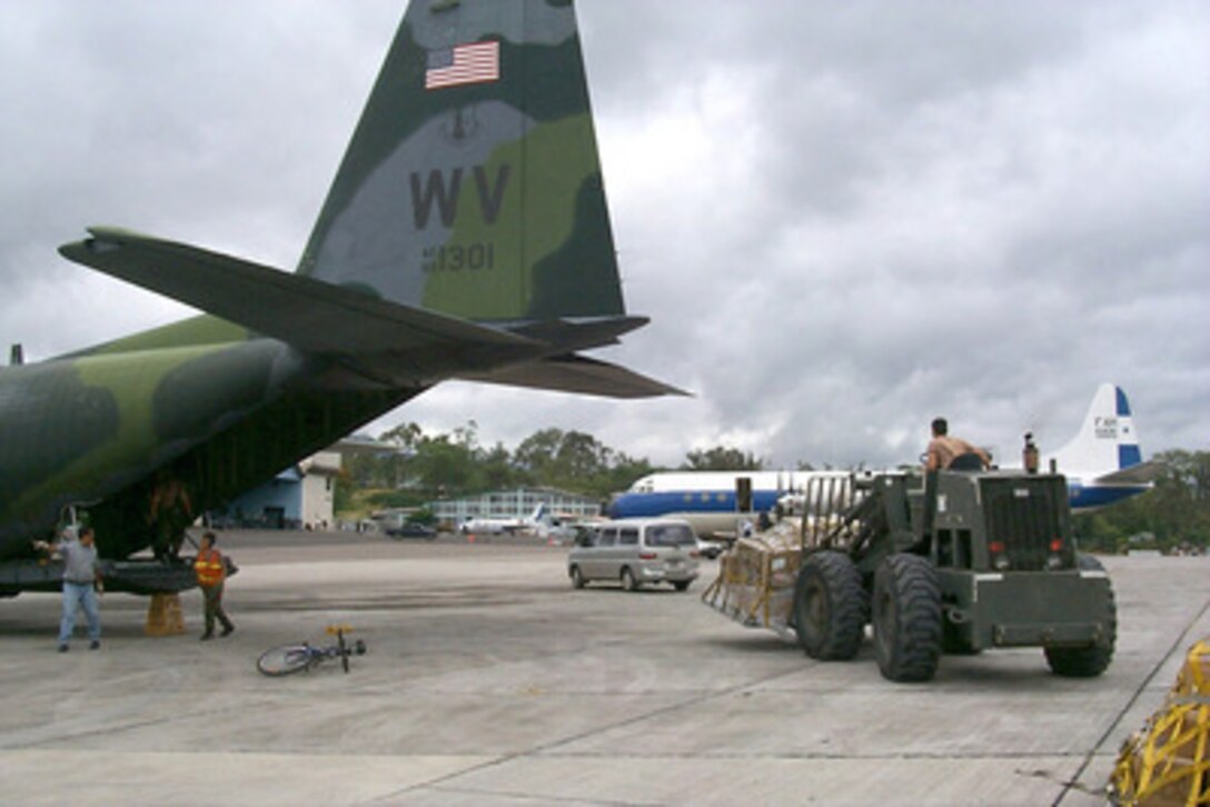 A forklift moves another pallet of relief supplies from a West Virginia Air National Guard C-130 Hercules to a staging area at the airport in Tegucigalpa, Honduras, on Nov. 11, 1998. Over 1,000 U.S. service members are helping to rush food, shelter, pure water and medical aid to the central Americans made homeless by Hurricane Mitch. 