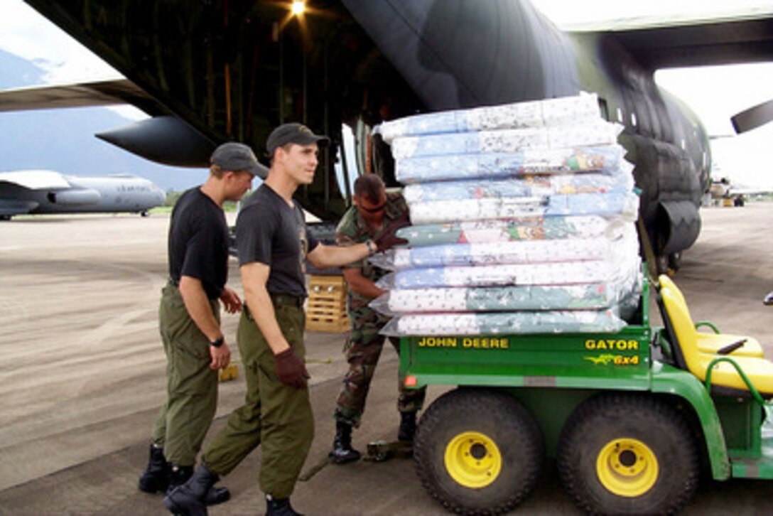 U.S. and Canadian service men unload mattresses and relief supplies for victims of Hurricane Mitch from a West Virginia Air National Guard C-130 Hercules at the airport in La Cieba, Honduras, on Nov. 11, 1998. Over 1,000 U.S. service members are helping to rush food, shelter, pure water and medical aid to the central Americans made homeless by Hurricane Mitch. 