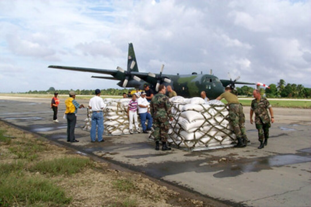 Local Hondurans, U.S. service men, and Netherlands service men prepare pallets of rice sacks for victims of Hurricane Mitch to be loaded on to a West Virginia Air National Guard C-130 Hercules at the airport in La Mesa, Honduras, on Nov. 11, 1998. Over 1,000 U.S. service members are helping to rush food, shelter, pure water and medical aid to the central Americans made homeless by Hurricane Mitch. 