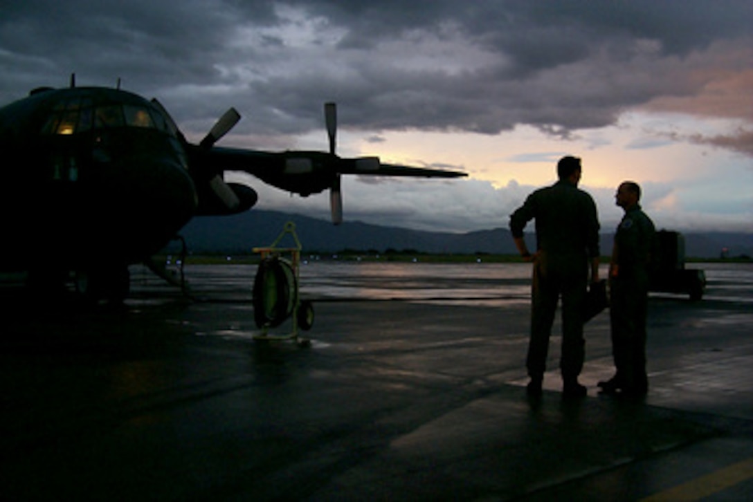 Two Air National Guardsmen wait as their West Virginia Air National Guard C-130 Hercules is refueled at Soto Cano Air Base, Honduras, on Nov. 11, 1998. Over 1,000 U.S. service members are helping to rush food, shelter, pure water and medical aid to the central Americans made homeless by Hurricane Mitch. 