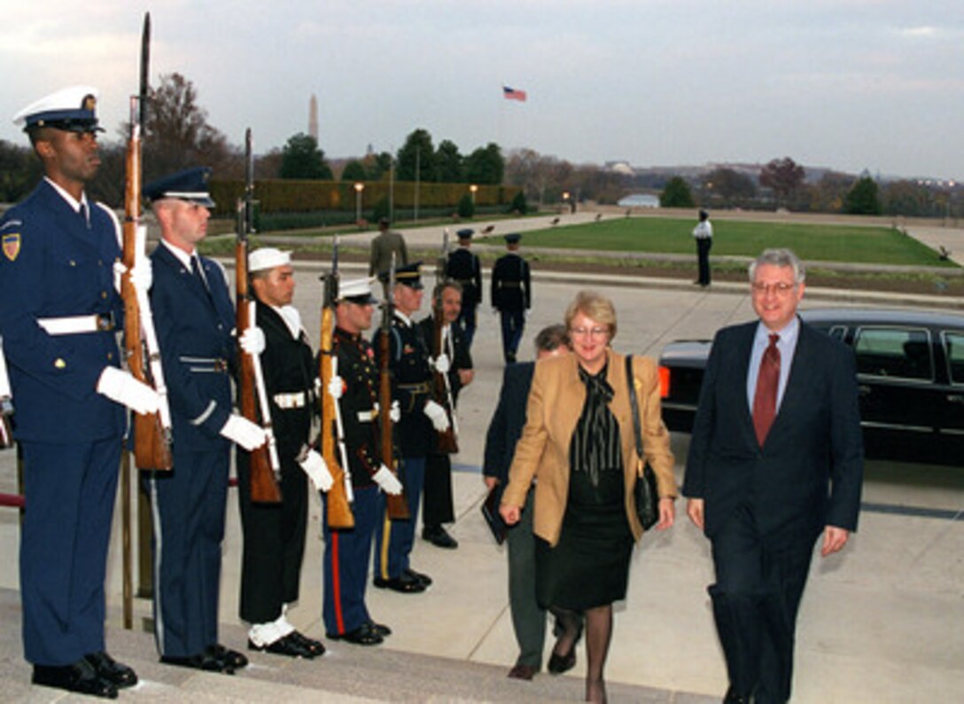 United Nations Deputy Secretary General Louise Frechette (left) is escorted into the Pentagon through an armed forces honor cordon by Deputy Secretary of Defense John J. Hamre (right) on Nov. 17, 1998. 