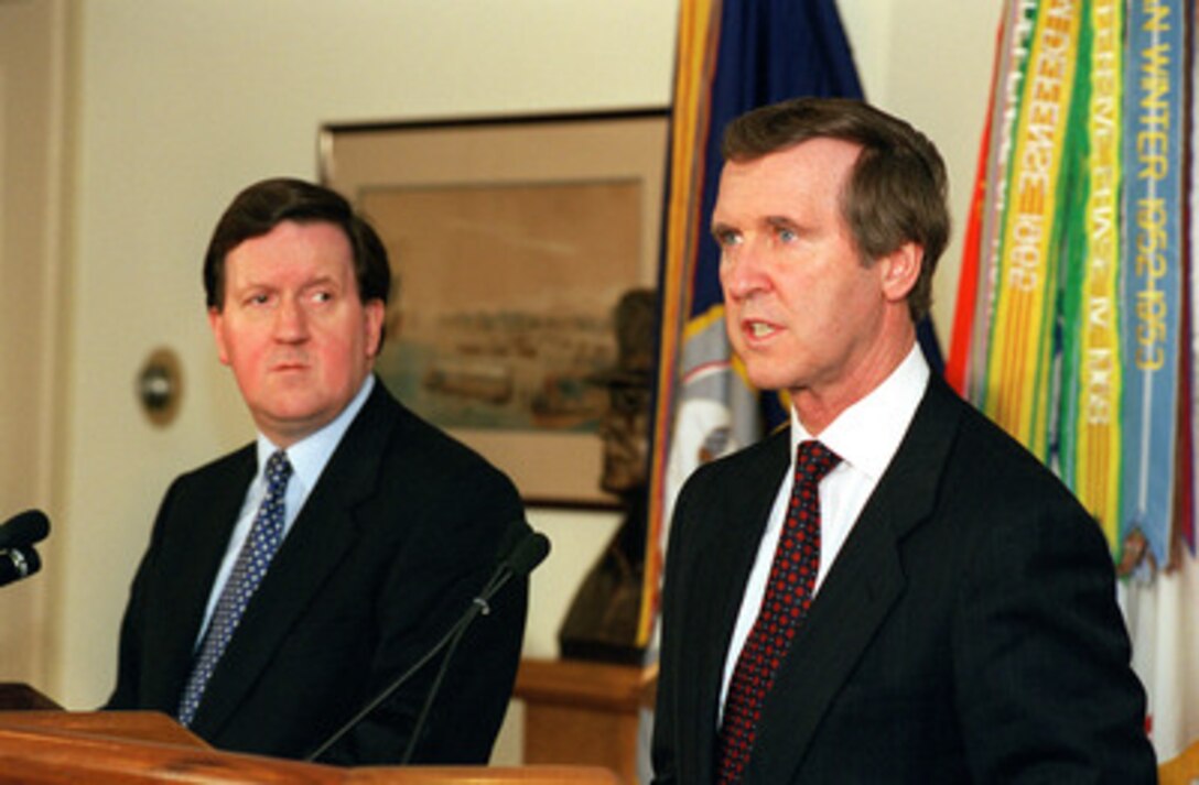 Secretary of State for Defense George Robertson, (left) of the United Kingdom of Great Britain and Northern Ireland, listens as Secretary of Defense William S. Cohen (right) responds to a reporter's question during a joint media availability in the Pentagon on Nov. 19, 1998. 
