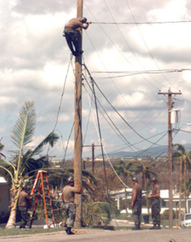 U.S. Navy SeaBees from Bravo Company of the Naval Mobile Construction Battalion work on power lines in the military housing area of Naval Station Roosevelt Roads, Puerto Rico, on Sept. 30, 1998. The lines were downed by the fierce winds of Hurricane Georges. Additionally, the Seabees are clearing roads and have performed minor repairs to municipal buildings in Puerto Rico to aid in the relief efforts. 