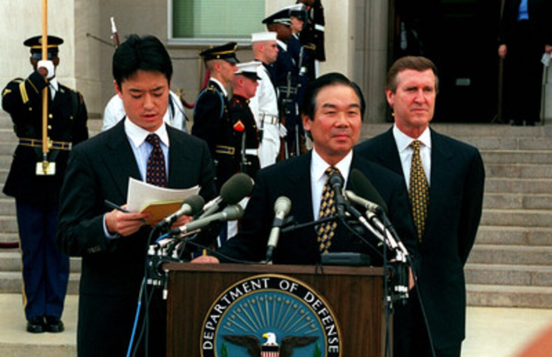Director General of the Japan Defense Agency Fukushiro Nukaga (center) waits as his interpreter (left) translates his remarks during a welcoming ceremony hosted by Secretary of Defense William S. Cohen (right) at the Pentagon on Sept. 21, 1998. 