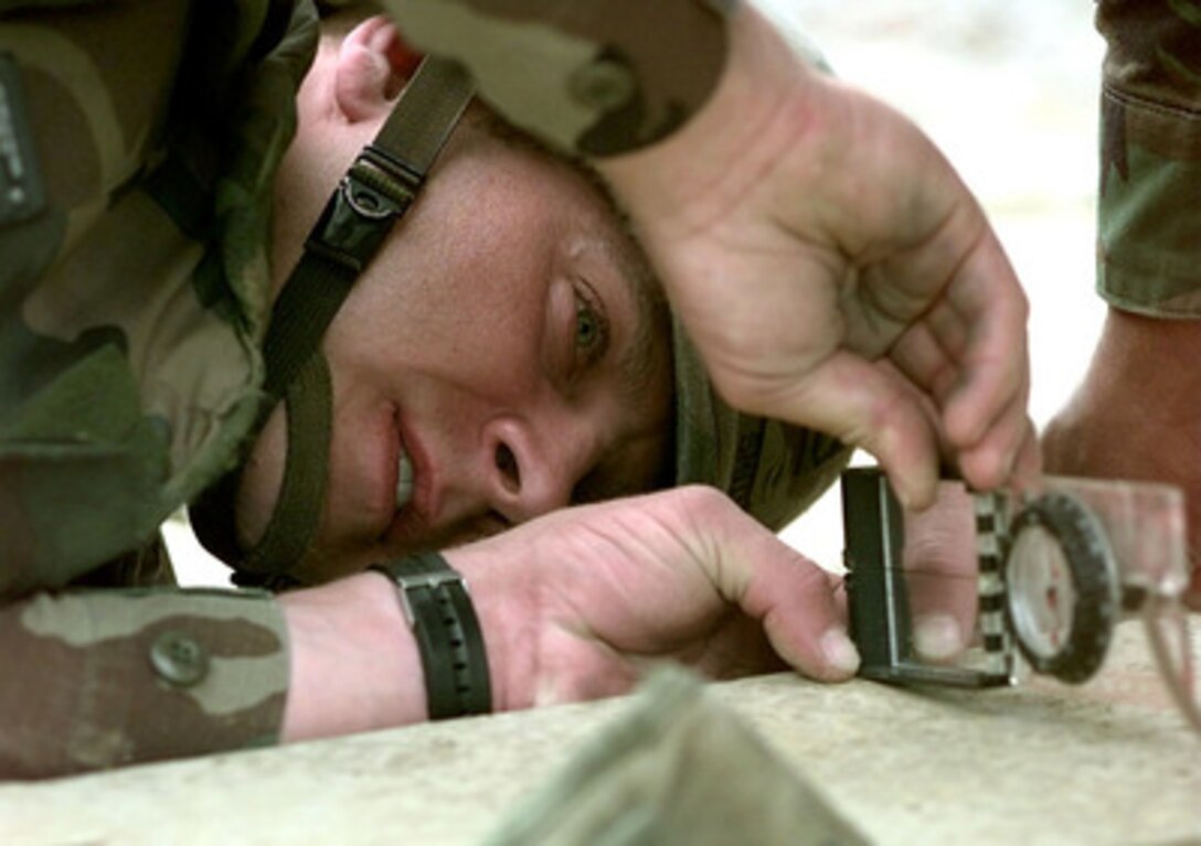 Combat Engineer Staff Sgt. Jerry Smith measures the percent of slope of the ground where a Mabey and Johnson bridge is to be constructed at Camp Demi near Kladanj, Bosnia and Herzegovina, on Sept. 27, 1998. The flooding Drinjaca river damaged the supports of the present bridge leading to the American army compound which was forced to close the gate used for multi-ton vehicle traffic. The construction of the bridge is a combined effort between the U.S. Army's Alpha Company, 40th Engineers 1st Platoon of Idar Oberstein, Germany; Alpha Company 20th Engineers 2nd Platoon, of Fort Hood, Texas; Brown and Root civilian contractors and Romanian Army Engineers. Smith is attached to the 40th Engineers. The engineers are deployed to Bosnia and Herzegovina to support Operation Joint Forge. 