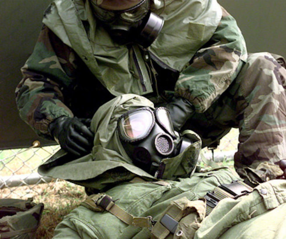 U.S. Army Pvt. Mateo Mateo-Gomez (above) adjusts Pfc. Matthew Bower's (below) gas mask after a simulated nerve agent attack during a Nuclear, Biological and Chemical exercise held at Camp Casey, Republic of Korea, on Oct. 9, 1998. Both soldiers are assigned to the 2nd Infantry Division, 4th Chemical Company at Camp Casey. 