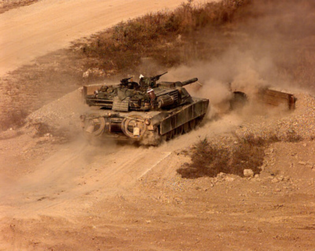 Dust flies as an M-1A1 Abrams main battle tank fires a round during live fire gunnery training at the Korea Training Center, Republic of Korea on Oct. 25, 1998. Armored units use the range to meet yearly, live gunnery training requirements. The tank is assigned to C Troop of the 4th Squadron, 7th Cavalry Regiment. 