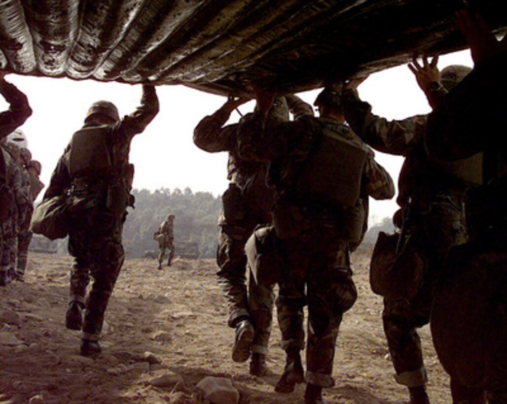 Soldiers assigned to the 50th Engineer Company, 1st Platoon, and the 2nd Battalion, 9th Infantry, team up to carry a rubber raft to the edge of the Imjin River in the Republic of Korea, on Oct. 22, 1998. The soldiers will cross the river in the raft during a simulated assault. Many of the soldiers are officers participating in the U.S. Army Officer Professional Development Program, which is designed to improve team building and soldiery. The 50th Engineers are from Camp Laguardia and the 9th Infantry are from Camp Casey in the Republic of Korea. 