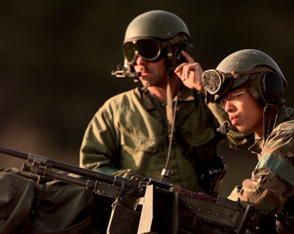 Two U.S. Army soldiers assigned to C Troop of the 4th Squadron, 7th Cavalry Regiment, relax atop their M-1A1 Abrams main battle tank after a long day of maneuvers and gunnery training at the Korea Training Center, Republic of Korea, on Oct. 25, 1998. Armored units use the range to meet yearly, live gunnery training requirements. 
