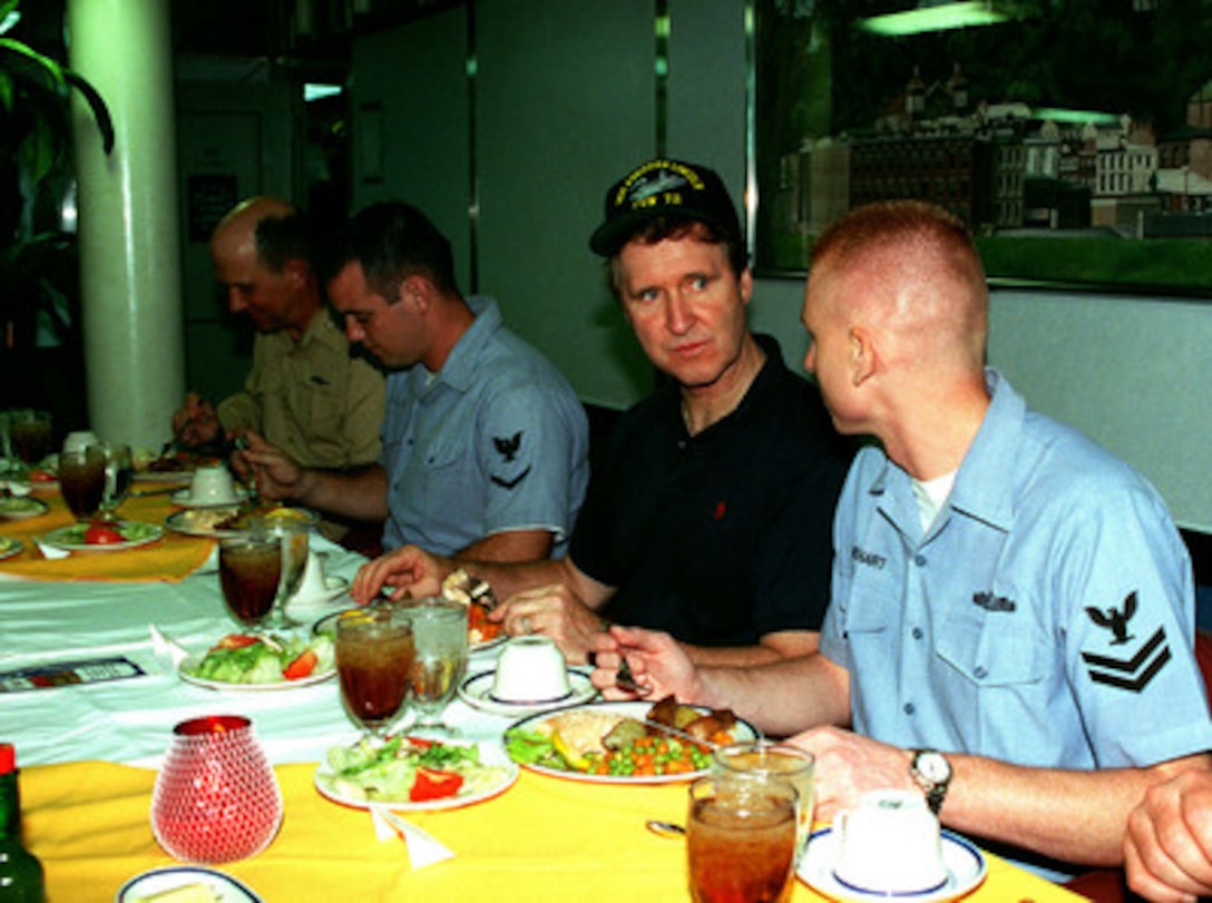Secretary of Defense William S. Cohen (with cap) talks with a sailor during lunch aboard the USS Abraham Lincoln (CVN 72) on Oct. 10, 1998, as the aircraft carrier operates in the Persian Gulf. Cohen is in the Persian Gulf region to visit with U.S. troops and heads of state in the Gulf countries. 