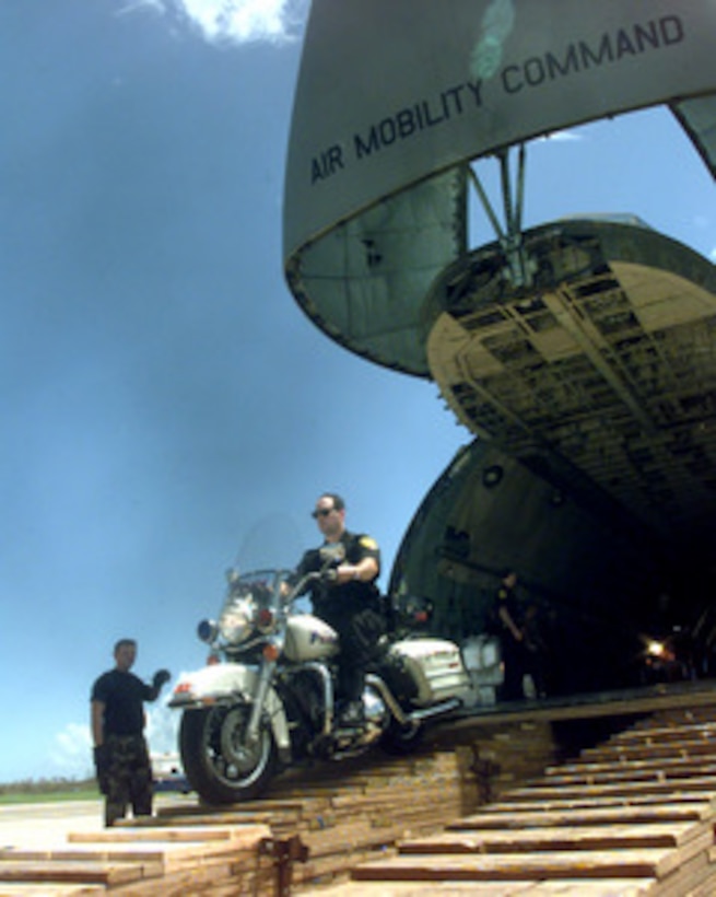 A U.S. Federal Protection Service member rides his police motorcycle off a U.S. Air Force C-5 Galaxy cargo aircraft at Naval Station Roosevelt Roads on Sept. 24, 1998. The C-5, from the 436th Air Mobility Wing, is one of many aircraft currently tasked to airlift people, equipment and supplies to Puerto Rico and neighboring Caribbean Islands struck by Hurricane Georges. 