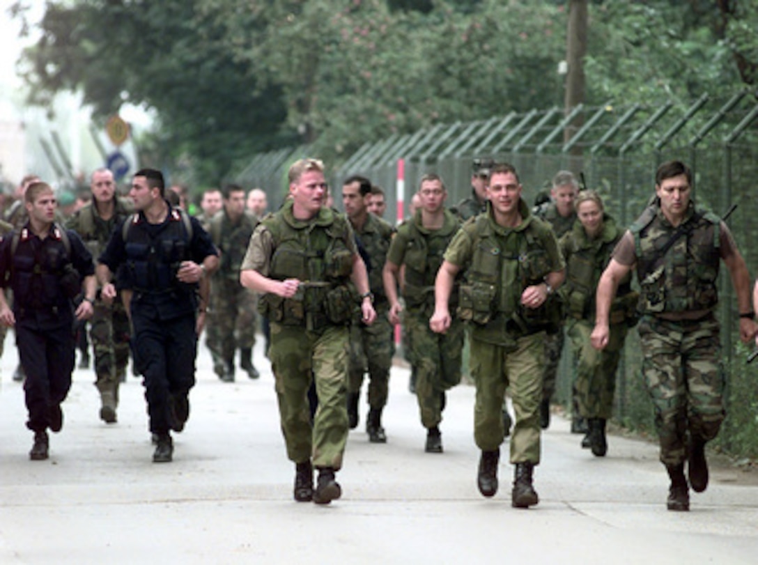 NATO Stabilization Force personnel begin the 30 kilometer Viking Run in the country side of Ilidza, Bosnia and Herzegovina, on Sept. 24, 1998. The Norwegian Army Telemark Company is hosting the Viking Run, an annual physical fitness test in the Norwegian Army. It consists of running 30 kilometers (18.5 miles) over rough terrain wearing a combat uniform, flack-jacket, long-barrel rifle, 2 full ammunition magazines, and a helmet totaling a minimum of 11 kilograms. One-hundred-five members of the NATO Stabilization Force are participating in the endurance run. 
