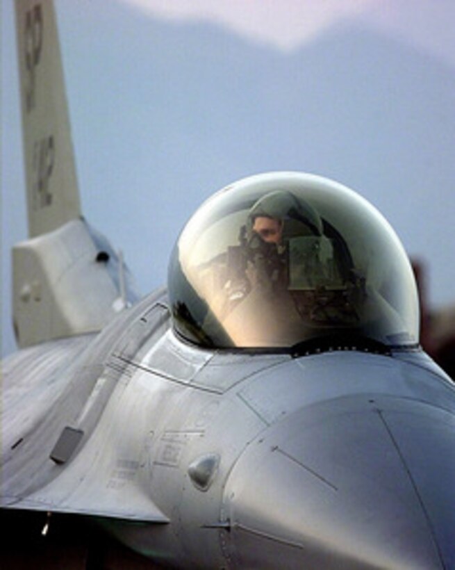 The pilot of a U.S. Air Force F-16 Fighting Falcon looks over his right wing as he prepares to take off from Aviano Air Base, Italy, on an air strike mission against targets in the Federal Republic of Yugoslavia on March 31, 1999, during NATO Operation Allied Force. The pilot and his Fighting Falcon are deployed to Aviano from the 23rd Fighter Squadron, Spangdahlem Air Base, Germany. 