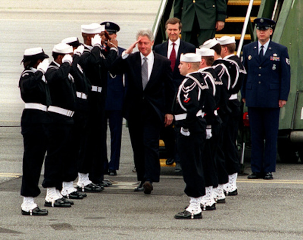 President Bill Clinton goes through the traditional Navy sideboys welcoming him aboard Norfolk Naval Station, Va., on April 1, 1999. Clinton is in Norfolk to address to U.S. and NATO military personnel, families, and civilian Department of Defense employees and to express thanks to personnel deployed overseas in support of U.S. and NATO operations. Following the President is Secretary of Defense William S. Cohen. 