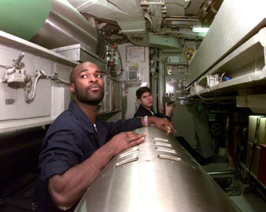 Seaman Daymond Jacobs (left) and Petty Officer 2nd Class Jim Piatt wait for further orders during a pre-load inspection of a Tomahawk cruise missile in the torpedo room aboard USS Norfolk (SSN 714) on March 31, 1999. The Los Angeles class attack submarine is operating in the Adriatic Sea in support of NATO Operation Allied Force. 