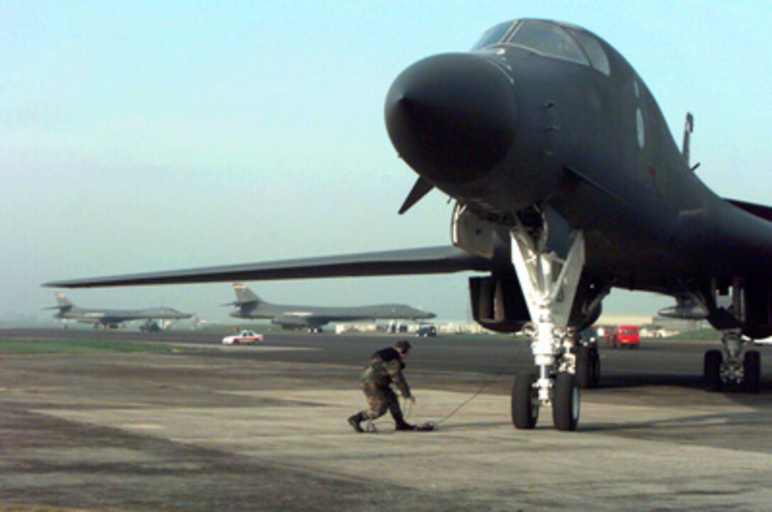 A ground crew member moves in to assist a U.S. Air Force B-1B Lancer bomber with aircraft shutdown procedures after arriving at RAF Fairford, United Kingdom, on April 1, 1999. The Lancers have been deployed from the 28th Bomb Wing, Ellsworth Air Force Base, S.D., to support NATO Operation Allied Force which is the air operation against targets in the Federal Republic of Yugoslavia. 