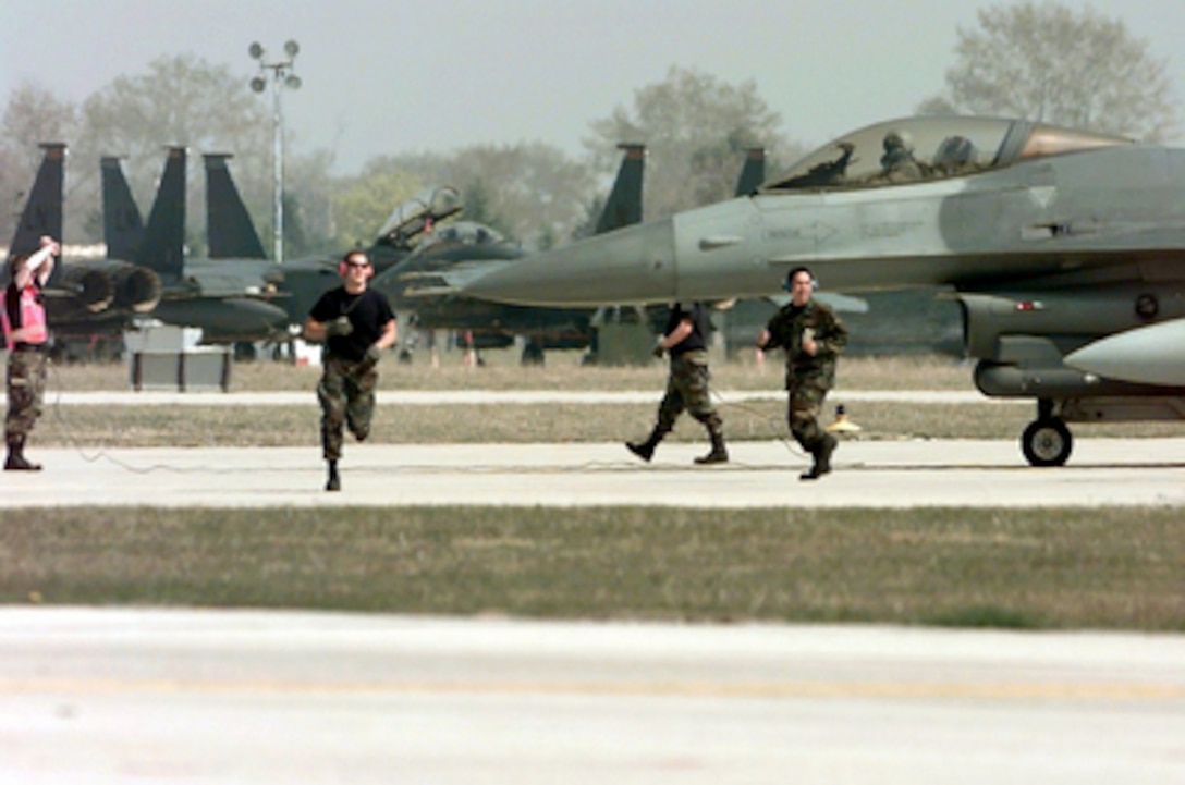 Ground crew personnel from the 555th Fighter Squadron, Aviano Air Base, Italy, hustle to prepare an F-16 Fighting Falcon for a NATO Operation Allied Force mission on April 3, 1999. Operation Allied Force is the air operation against targets in the Federal Republic of Yugoslavia. 