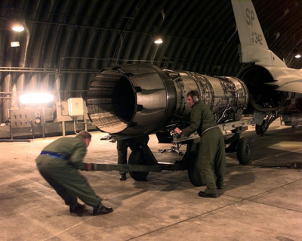 U.S. Air Force crew chiefs muscle an engine into position for installation in an F-16 Fighting Falcon on April 7, 1999, at Aviano Air Base, Italy. These crew chiefs from the 23rd Fighter Squadron, Spangdahlem Air Base, Germany, are keeping pace with the maintenance associated with the increased operating tempo of NATO Operation Allied Force. Operation Allied Force is the air operation against targets in the Federal Republic of Yugoslavia. 