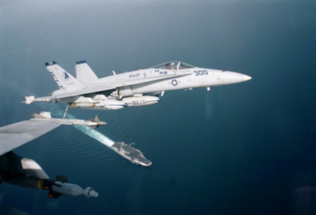 A pair of F/A-18C Hornets fly over the aircraft carrier USS Enterprise (CVN 65) after completing a mission in support of Operation Southern Watch on April 10, 1999. Enterprise and its embarked Carrier Air Wing 3 are on station in the Persian Gulf in support of Operation Southern Watch which is the U.S. and coalition enforcement of the no-fly-zone over Southern Iraq. The Hornets are attached to Strike Fighter Squadron 37. 