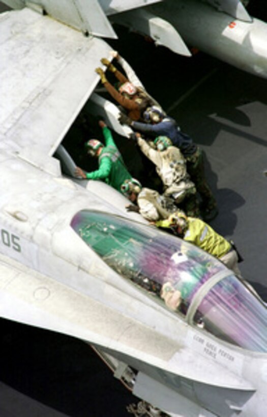 Flight deck crew members push an F/A-18C Hornet into position for tie-down the flight deck of the USS Enterprise (CVN 65) on April 8, 1999. Enterprise and its embarked Carrier Air Wing 3 are on station in the Persian Gulf in support of Operation Southern Watch, which is the U.S. and coalition enforcement of the no-fly-zone over Southern Iraq. 
