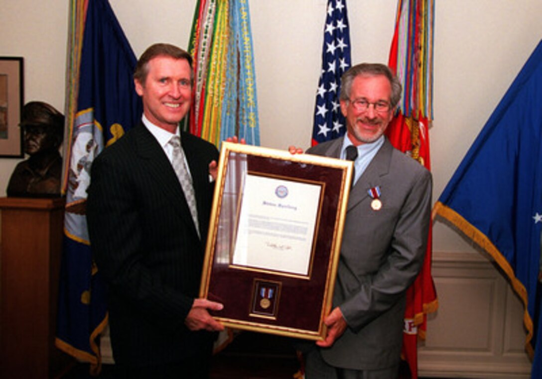 Secretary of Defense William S. Cohen (left) presents a framed citation accompanying the Department of Defense Medal for Distinguished Public Service to Steven Spielberg (right) on Aug. 11, 1999, in the Pentagon. Cohen presented Spielberg the award in recognition of the impact his movie "Saving Private Ryan" has had on the American people. According to the citation accompanying the medal, "... Mr. Spielberg helped to reconnect the American public with its military men and women, while rekindling a deep sense of gratitude for the daily sacrifices they make on the front lines of our Nation's defense." 