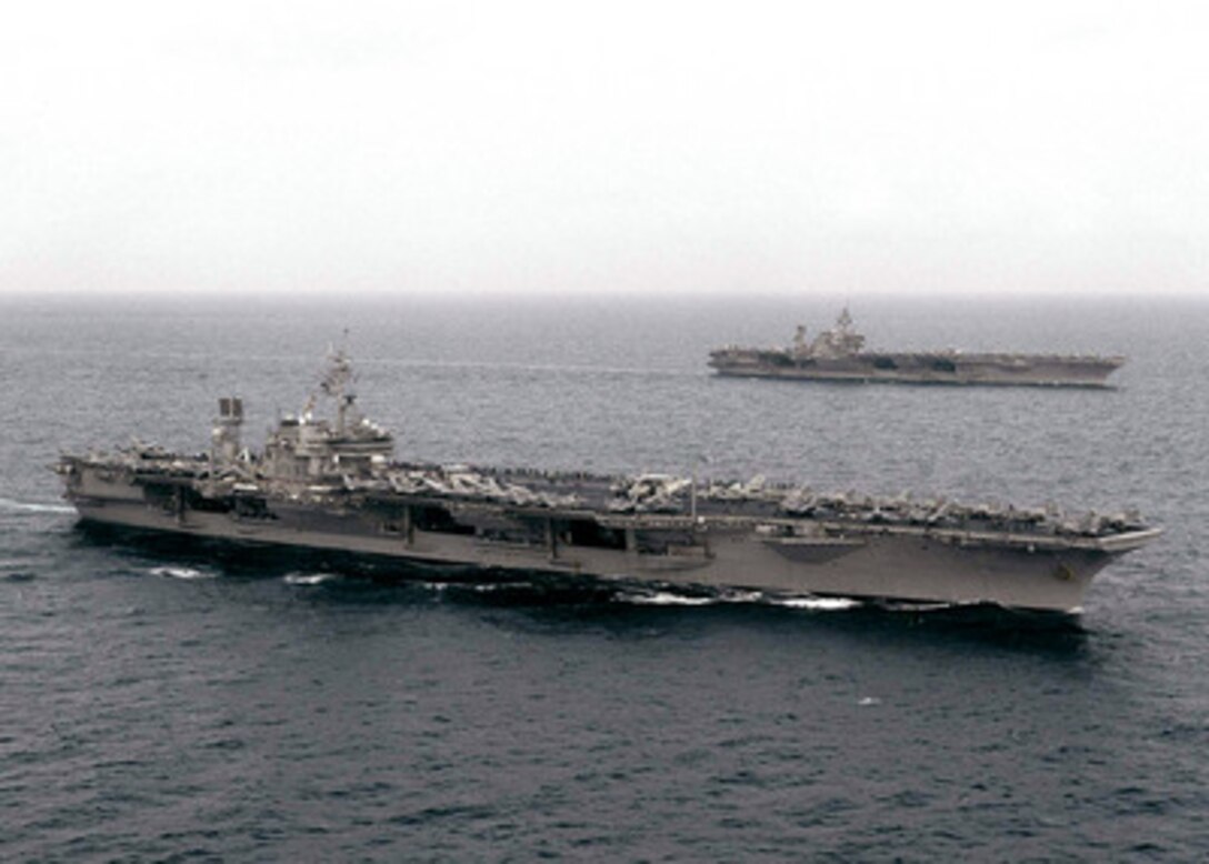 The USS Constellation (CV 64) (foreground) steams alongside the USS Kitty Hawk (CV 63) in the South China Sea on Aug. 8, 1999. The two aircraft carriers and their embarked air wings are conducting a brief exercise as they operate together. The Constellation is steaming toward the Persian Gulf for a deployment, while the Kitty Hawk is returning from a deployment in the Persian Gulf. 