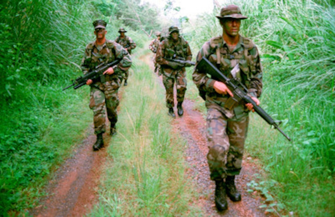 U.S. Marines search the tree line for trails left by intruders during a jungle patrol on Fort Howard, Panama, on June 11, 1999. The Marines are providing security during the turn over of the Panama Canal and U.S. bases to the Panamanian government. Marines from Echo Company, 2nd Battalion, 8th Marine Regiment are part of the United States Security Detachment Panama, Marine Forces South. 