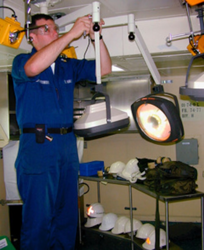 Petty Officer 1st Class William Lewandowski installs an examination light in a medical examining room on board the USS Kearsarge (LHD 3) on Aug. 19, 1999. The Kearsarge, USS Ponce (LPD 15) and USS Gunston Hall (LSD 44) and the 2,100 embarked Marines of the 26th Marine Expeditionary Unit (MEU) have been ordered to the vicinity of Istanbul, Turkey, to assist in the ongoing humanitarian and medical relief assistance in the aftermath of the recent earthquake in western Turkey. The Kearsarge Amphibious Ready Group and its embarked 26th MEU's comprehensive medical facilities enable the ships to provide effective care and disaster relief in support of humanitarian missions. The three-ship group contains approximately 631 beds, six operating rooms and five X-ray rooms. Eight medical doctors, three dental officers and 88 medical corpsmen are assigned to the ships. Lewandowski is a Navy hospital corpsman. 