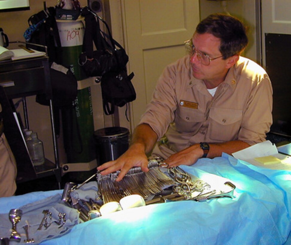 Cmdr. Bruce Potenza examines surgical instruments on board the USS Kearsarge (LHD 3) on Aug. 19, 1999. The Kearsarge, USS Ponce (LPD 15) and USS Gunston Hall (LSD 44) and the 2,100 embarked Marines of the 26th Marine Expeditionary Unit (MEU) have been ordered to the vicinity of Istanbul, Turkey, to assist in the ongoing humanitarian and medical relief assistance in the aftermath of the recent earthquake in western Turkey. The Kearsarge Amphibious Ready Group and its embarked 26th MEU's comprehensive medical facilities enable the ships to provide effective care and disaster relief in support of humanitarian missions. The three-ship group contains approximately 631 beds, six operating rooms and five X-ray rooms. Eight medical doctors, three dental officers and 88 medical corpsmen are assigned to the ships. Potenza, a Navy Reserve doctor whose specialty is trauma and critical care, was activated from Fleet Hospital Unit 23 at the Naval Reserve Center in Madison, Wis. 