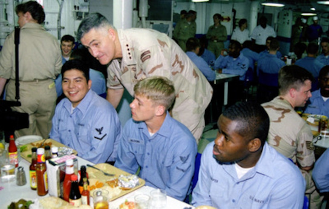 Chairman of the Joint Chiefs of Staff Gen. Henry H. Shelton (standing), U.S. Army, talks with crew members of the USS Theodore Roosevelt (CVN 71) as they eat lunch on Aug. 19, 1999. The aircraft carrier is deployed to the Persian Gulf in support of Operation Southern Watch which is the U.S. and coalition enforcement of the no-fly-zone over Southern Iraq. Shelton is onboard the carrier during a visit to the Persian Gulf region. 