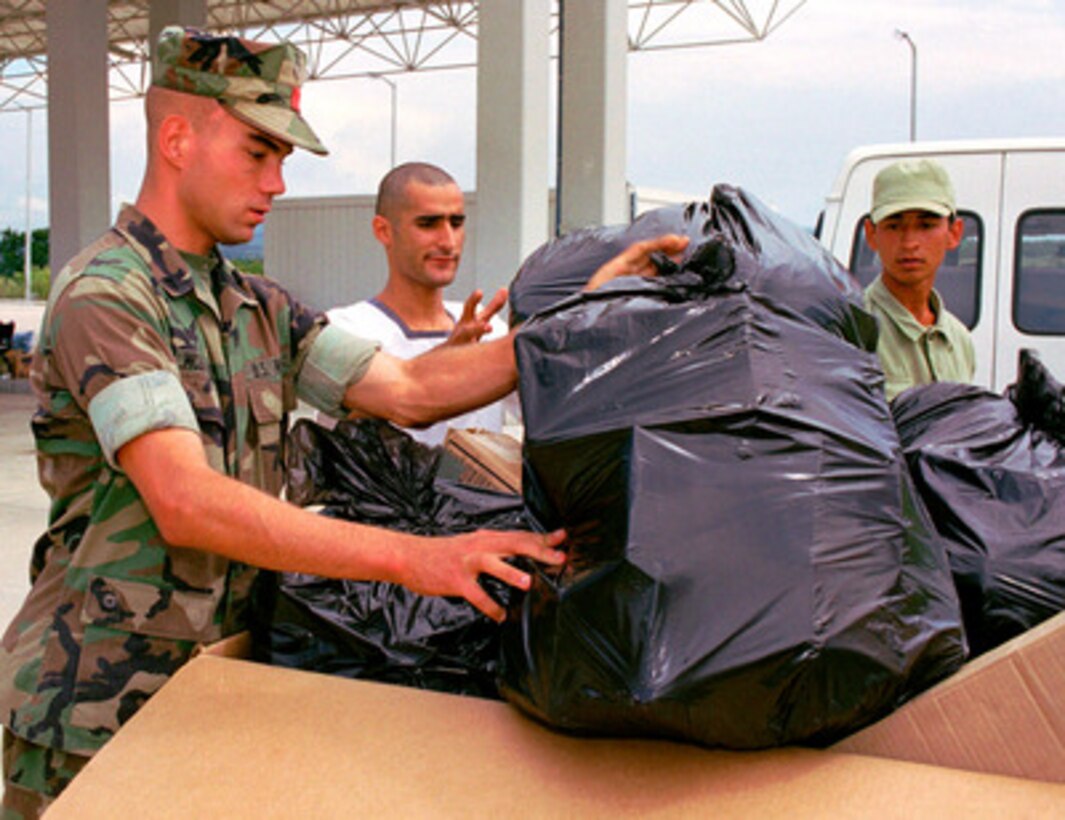 A U.S. Marine and two Turkish sailors load bags of toothpaste, soap, diapers and other hygiene supplies into a cargo box for the crisis center at the Turkish Naval Base at Topel, Turkey, on Aug. 26, 1999. The Kearsarge Amphibious Readiness Group and the 26th Marine Expeditionary Unit are in Turkey to aid victims of the recent earthquake as part of Operation Avid Response. Avid Response is the U.S. military contribution to relief efforts following the earthquake that hit Western Turkey in the early morning hours of Aug. 17, 1999. The U.S. Marine Corps is creating a warehouse area at Topel for relief agencies to dispense goods to earthquake victims. 
