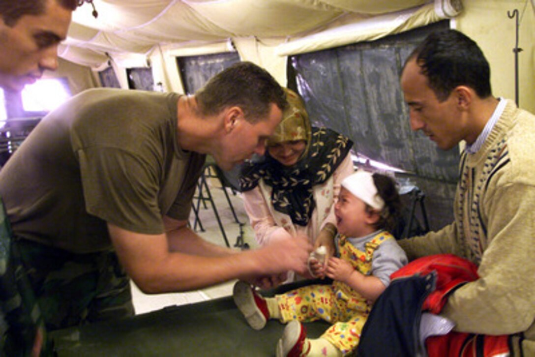 Lt. Jeff Bledsoe provides medical attention to a Turkish girl in a U.S. Navy medical tent in Izmit, Turkey, on Aug. 25, 1999. The young girl was injured in the earthquake that hit Western Turkey in the early morning hours of Aug. 17, 1999. Bledsoe, a U.S. Navy operating room nurse, is part of a 22-person medical team deployed from Naples, Italy, to Turkey to aid victims of the recent earthquake as part of Operation Avid Response. Avid Response is the U.S. military contribution to relief efforts following the earthquake. 