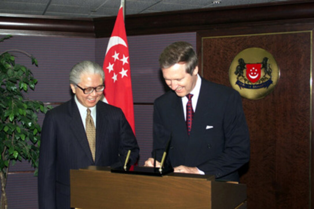 Secretary of Defense William S. Cohen (right) signs the guest book upon his arrival at the Ministry of Defense, Singapore, on Oct. 2, 1999, as his host Deputy Prime Minister Tony Tan watches. Cohen is traveling through the Western Pacific to meet with senior government leaders. 