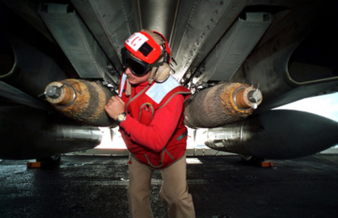 Chief Aviation Ordnanceman Paul K. Hillard makes a final inspection of the firing pins of 500-pound bombs mounted underneath an F-14 Tomcat on the flight deck off the USS Dwight D. Eisenhower (CVN 69) on Dec. 6, 1999. The Eisenhower and its embarked Carrier Air Wing 7 are operating in the Atlantic Ocean as part of Joint Task Force Exercises in preparation for a six-month deployment to the Mediterranean Sea. 