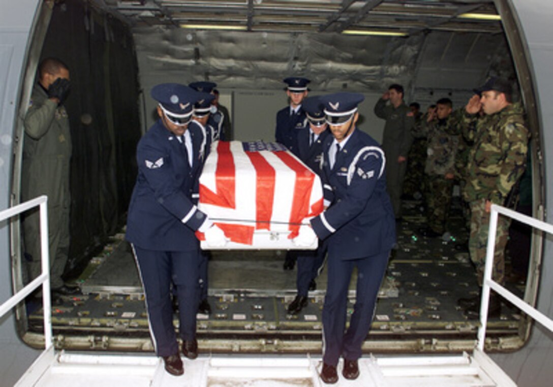 Aircrew and passengers salute one of their own as members of the Team McGuire Elite Honor Guard carry the remains of a U.S. Air Force airman killed in a C-130 Hercules mishap to a waiting hearse at McGuire Air Force Base, N.J., on Dec. 14, 1999. Three servicemen were killed when the C-130 Hercules they were flying in made an emergency landing at Kuwait City, Kuwait, on Dec. 10. 