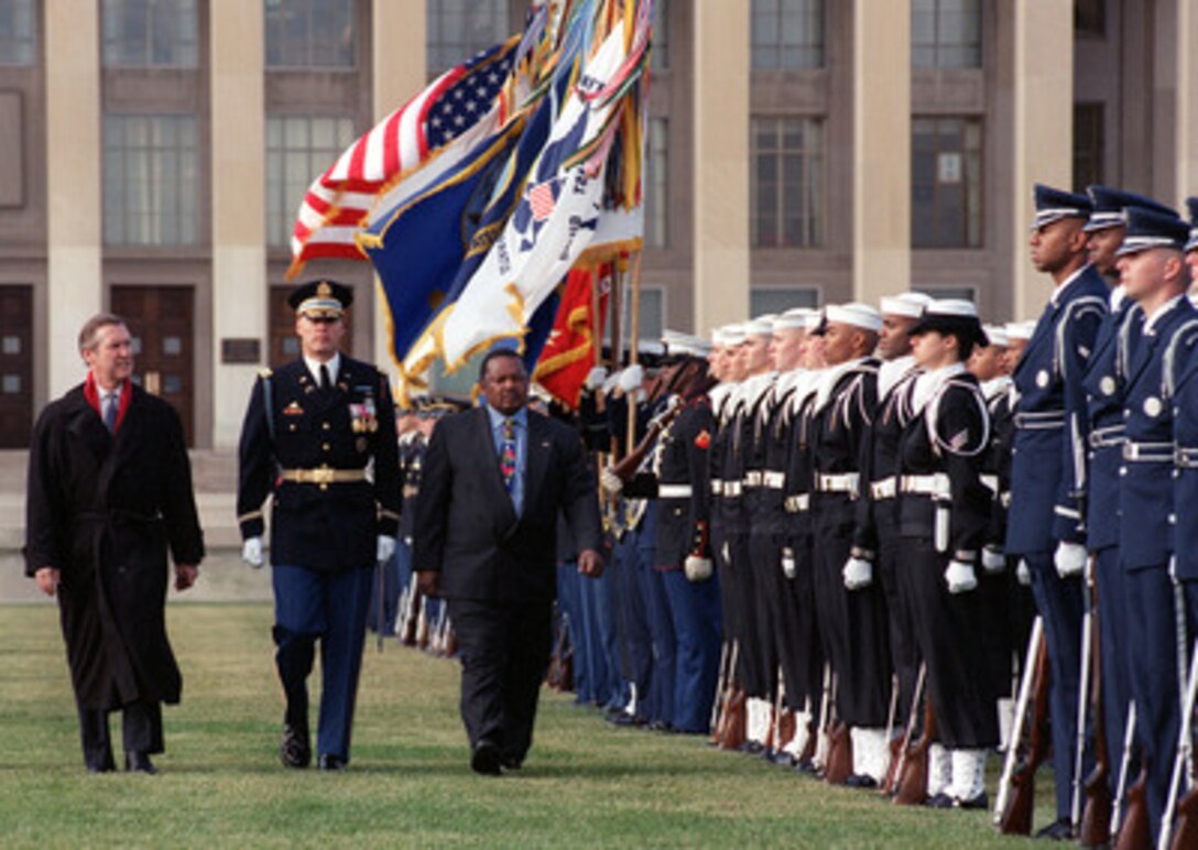 South African Minister of Defense Patrick Lekota (right) is accompanied by Col. Thomas M. Jordan (center), U.S. Army, and Secretary of Defense William Cohen (left) as Lekota inspects the joint services honor guard during a welcoming ceremony for him at the Pentagon on Dec. 7, 1999. Cohen and Lakota will later have a private meeting and a plenary session involving delegations from both nations to discuss a range of regional and global security issues. 