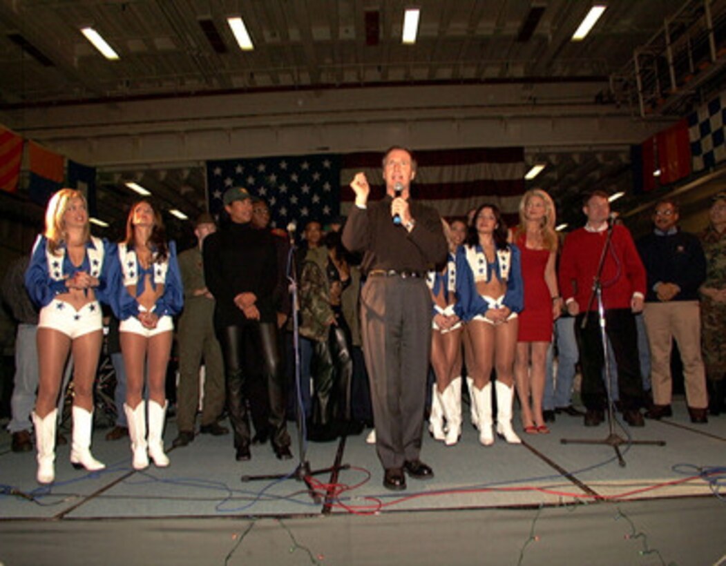 ABOARD USS BATAAN (December 21, 1999) - U.S. Secretary of Defense William S. Cohen praises Sailors and Marines aboard the landing helicopter dock ship USS Bataan (LHD 5) as celebrities supporting Christmas USO Show look on. Cohen's stop aboard Bataan was the first of several visits to military units operating through southern Europe and the Balkans during the Christmas and New Year's holiday season. 