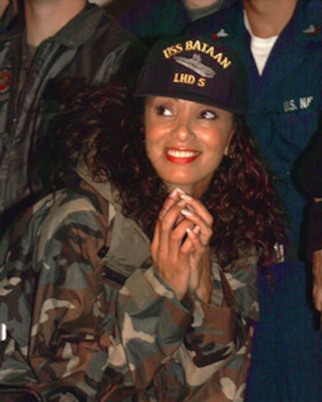 ABOARD USS BATAAN (December 21, 1999) - Downtown Julie Brown pauses to enjoy the Christmas USO Show hosted by U.S. Secretary of Defense William S. Cohen aboard the landing helicopter dock ship USS Bataan (LHD 5). Cohen's stop aboard Bataan was the first of several visits to military units operating through southern Europe and the Balkans during the Christmas and New Year's holiday season. 