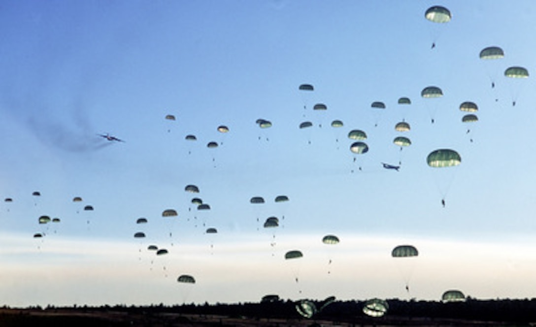Soldiers of the U.S. Army's 82nd Airborne float to the ground at Normandy drop zone on Fort Bragg, N.C., after jumping from U.S. Air Force C-141 Starlifters on Jan. 20, 1999. The soldiers are participating in Large Package Week, a joint exercise involving Air Force aircraft operating from Pope and soldiers of the U.S. Army's 82nd Airborne, at Fort Bragg, N.C. 
