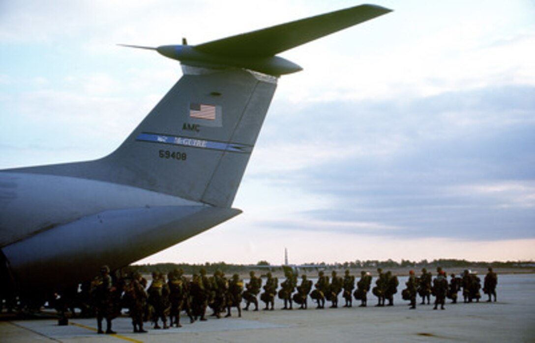 Soldiers of the U.S. Army's 82nd Airborne line up for loading into a U.S. Air Force C-141 Starlifter at Pope Air Force Base, N.C., on Jan. 20, 1999. The soldiers are participating in Large Package Week, a joint exercise involving Air Force aircraft operating from Pope and soldiers of the U.S. Army's 82nd Airborne, at Fort Bragg, N.C. The Starlifter is deployed to Pope from McGuire Air Force Base, N.J. 
