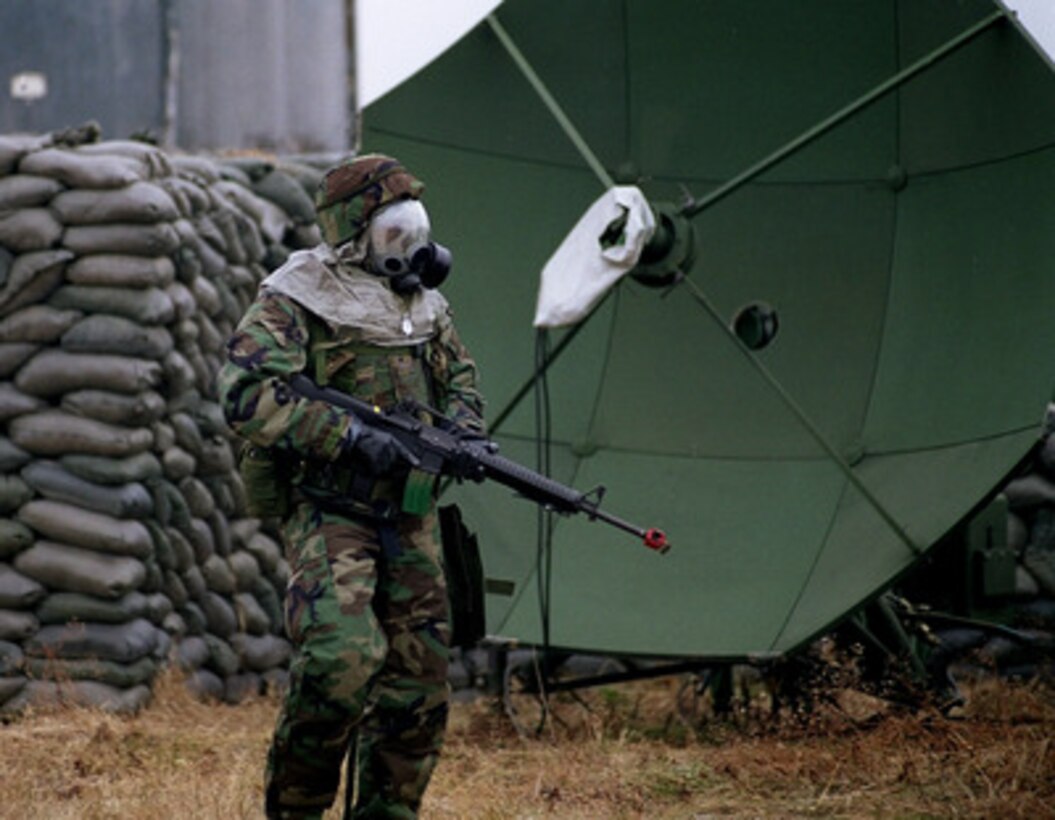 A member of the U.S. Air Force 51st Security Forces Squadron conducts a search through an industrial facility on Jan. 6, 1999, as part of combat employment readiness exercise Beverly Midnight 99-1, at Osan Air Base, Republic of Korea. The exercise is designed to test people's ability to carry out their wartime tasking, air base ground defense, and ability to recover after attacks. During the exercise, personnel quickly become accustomed to working and resting while wearing the Ground Crew Ensemble and its MCU-2P chemical/biological protective mask to protect themselves from chemical warfare agents. 