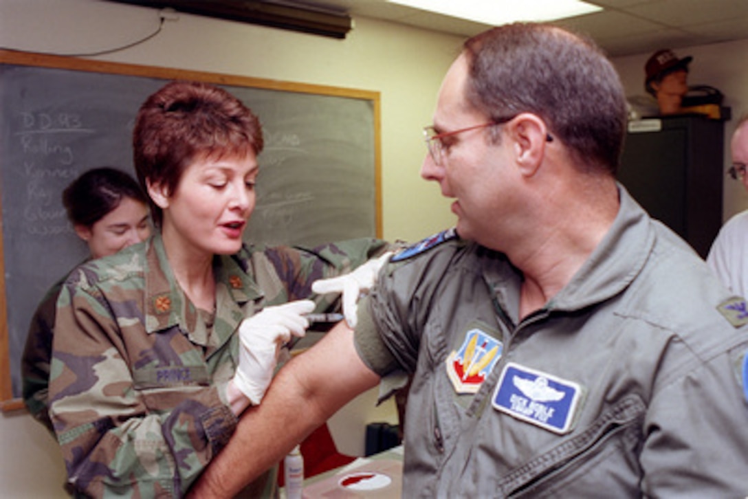 Air National Guard Col. Richard Noble (right), receives the first of a series of anthrax inoculations from Maj. Theresa Prince (left) at McEntire Air National Guard Station, S.C., on Jan. 9, 1999. Noble volunteered to be the first member of the 169th Fighter Wing to receive his anthrax inoculation. Noble is the vice commander of the 169th which flies the F-16C Fighting Falcon. Prince is chief of nursing services of the 169th Medical Squadron at McEntire. 