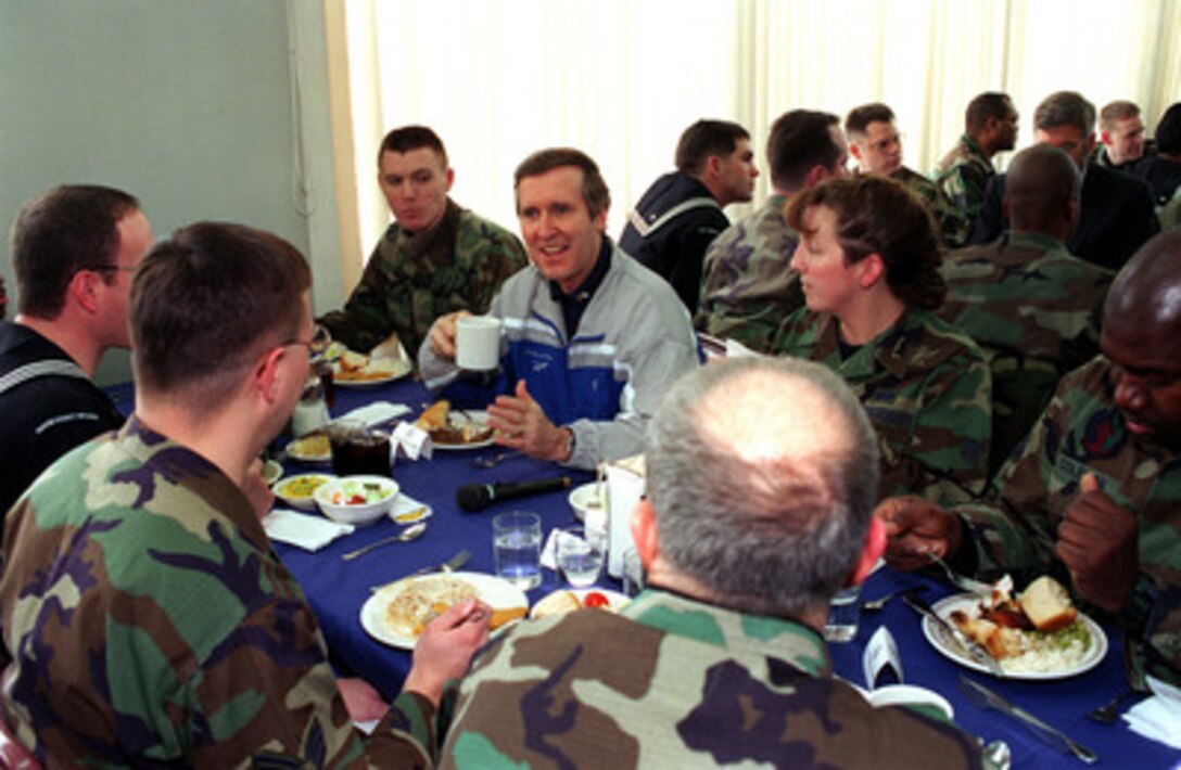 Secretary of Defense William Cohen (center) enjoys lunch and conversation with some of the men and women of the U.S. armed forces serving at Misawa Air Base, Japan, at the Falcon Feeder dining facility on Jan. 12, 1999. Cohen is visiting the base as part of a five-day trip to Japan and the Republic of Korea. The base is a joint use facility serving the Japan Defense Forces as well as the U.S. Air Force and Navy. 