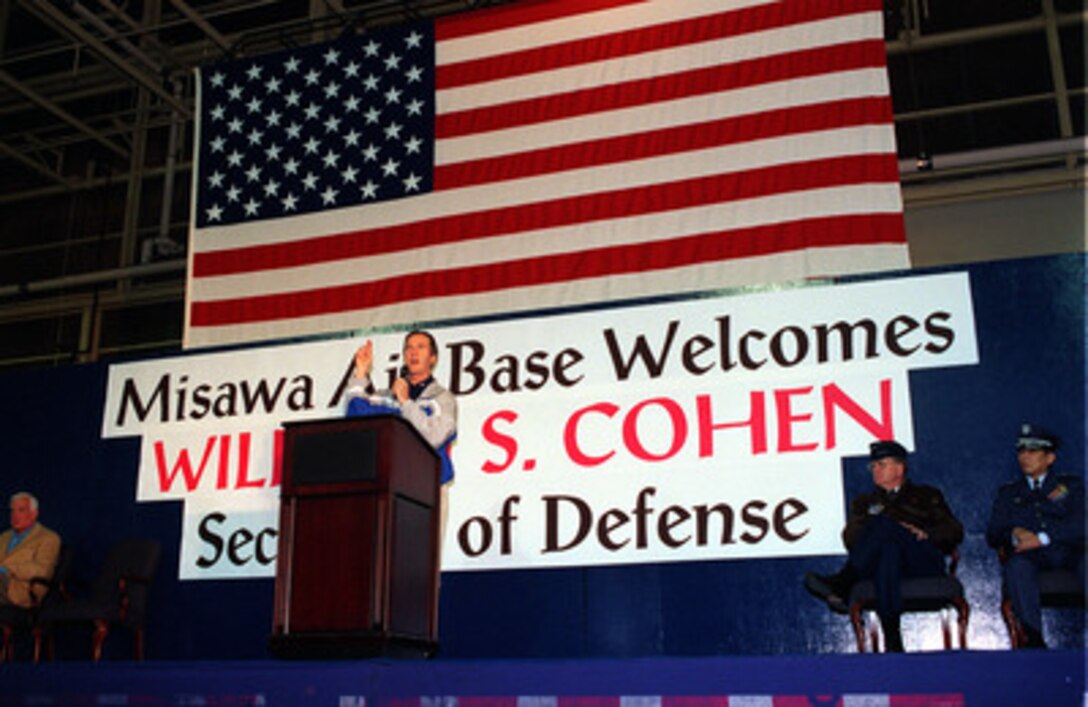Secretary of Defense William S. Cohen speaks to an audience of American military personnel stationed at Misawa Air Base, Japan, on Jan. 12, 1999. Cohen is visiting the base as part of a five-day trip to Japan and the Republic of Korea. The base is a joint use facility serving the Japan Defense Forces as well as the U.S. Air Force and Navy. Joining Cohen on stage are U.S. Ambassador Thomas Foley (left), Lt. Gen. John Hill (2nd from right), U.S. Air Force, commander, U.S. Forces Japan, and Lt. Gen. Katsuhiko Iwasaki (right), commander of the Japan Northern Air Defense Force. 