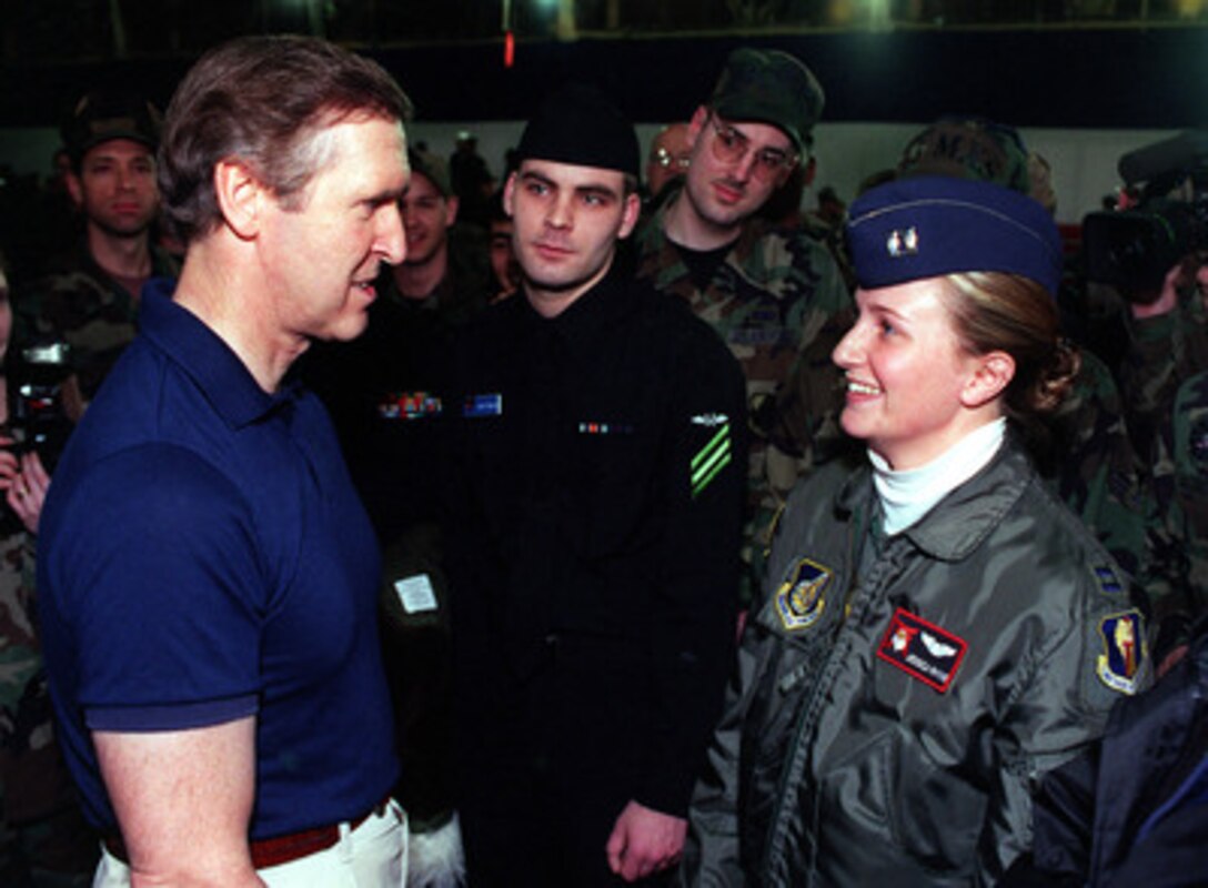 Secretary of Defense William Cohen (left) talks with Capt. Jessica Rhyne (right), a U.S. Air Force F-16 Fighting Falcon pilot, during his visit to Misawa Air Base, Japan, Jan. 12, 1999. Cohen is visiting the base as part of a five-day trip to Japan and the Republic of Korea. The base is a joint use facility serving the Japan Defense Forces as well as the U.S. Air Force and Navy. 