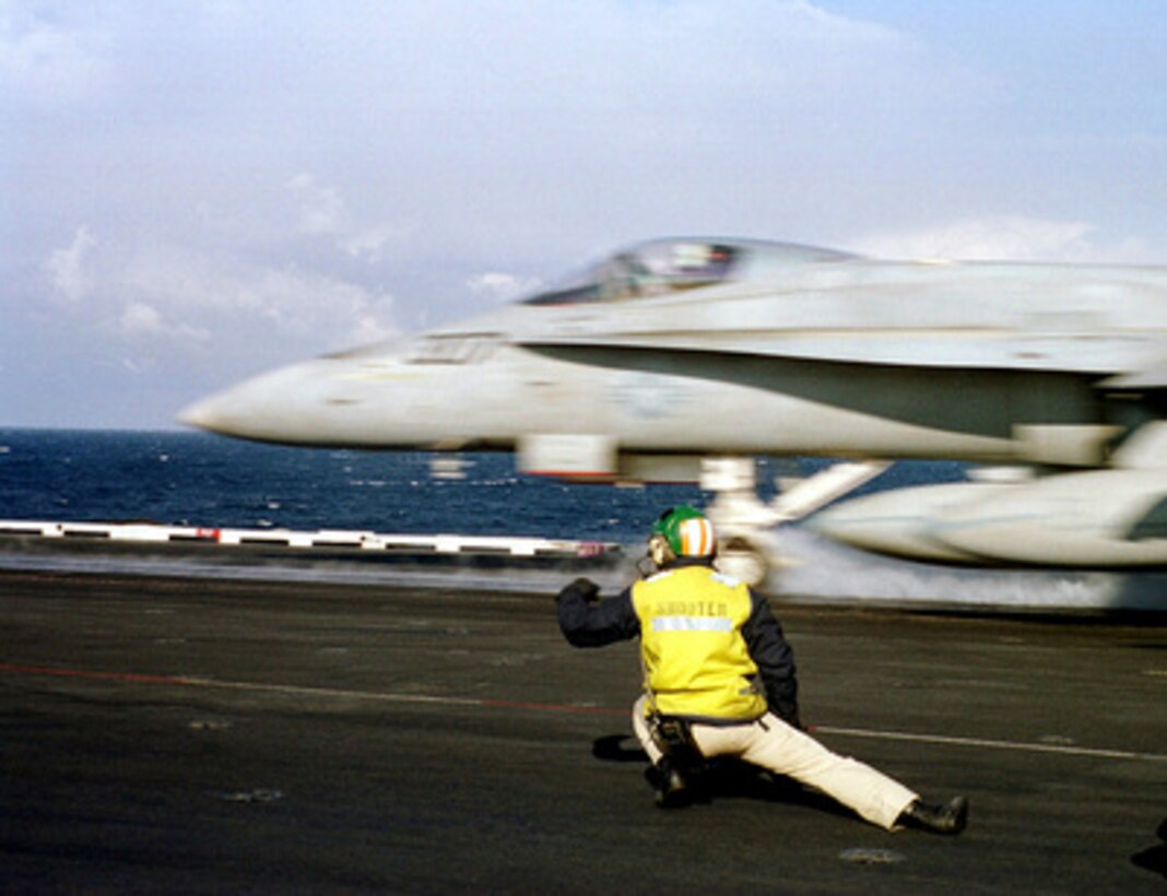 The catapult shooter ducks as an F/A-18 Hornet hurtles down the catapult of the USS Enterprise (CVN 65) as the ship conducts flight operations in the Mediterranean Sea on Feb. 12, 1999. 