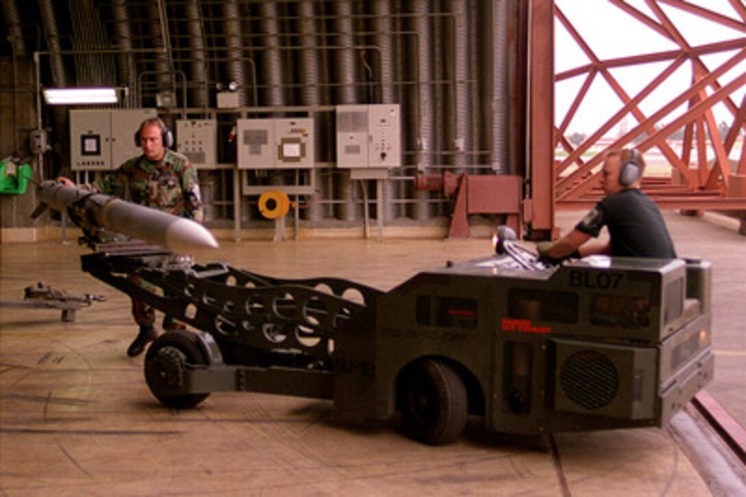 U.S. Air Force Staff Sgt. Jay Jarvis (left) and Senior Airman Brian Warfel transport an AIM-120 Advanced Medium-Range Air to-Air Missile, or AMRAAM, for loading onto an F-15C Eagle at Incirlik Air Base, Turkey, during Operation Northern Watch on Feb. 16, 1999. Northern Watch is the coalition enforcement of the no-fly-zone over Northern Iraq. Jarvis and Warfel are weapons load crew members attached to the 493rd Expeditionary Fighter Squadron at Incirlik. 